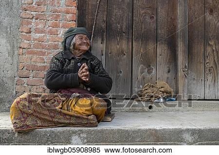Friendly smiling elderly woman with headscarf and nose ring sitting in front of a wooden door, Himalaya, Jiri, Khumbu region, Nepal, Asia View Large Photo Image Stock Photography - Friendly smiling elderly woman with headscarf and nose ring sitting in front of a wooden door, Himalaya, Jiri, Khumbu region, Nepal, Asia. Fotosearch