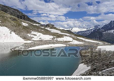 Stock Photo - Friesenbergsee with Friesenberghaus in front of snowy mountains, Zillertal Alps, Zillertal, Tyrol, Austria, Europe. Fotosearch