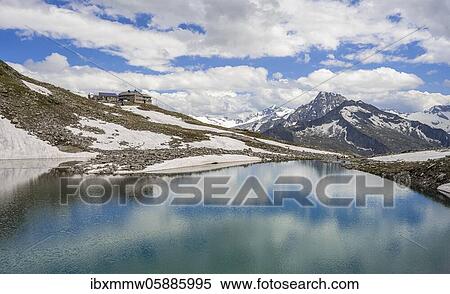 Stock Photography - Friesenbergsee with Friesenberghaus in front of snowy mountains, Zillertal Alps, Zillertal, Tyrol, Austria, Europe. Fotosearch