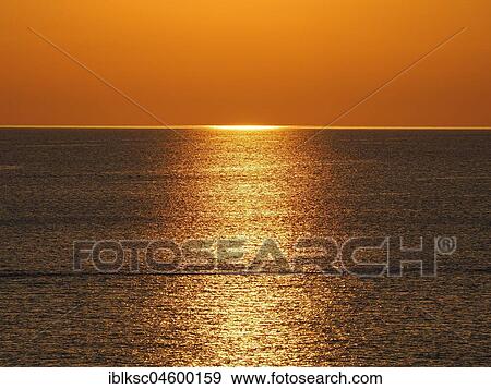 Stock Photo - Golden light reflections at sunset in the sea, Corsica, France, Europe. Fotosearch