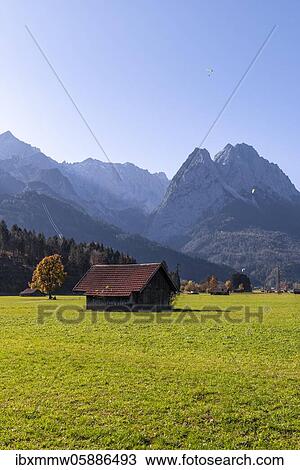 Stock Image - Hay barn, green meadow, Zugspitze in the background, mountain landscape, near Grainau, Garmisch-Partenkirchen, Upper Bavaria, Bavaria, Germany, Europe. Fotosearch
