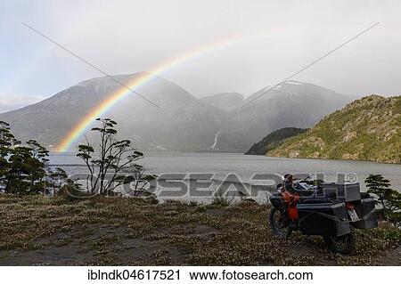 Heavily packed motorcycle in front of a lake behind a rainbow, O higgins, Region de Aysen, Chile, South America View Large Photo Image Stock Image - Heavily packed motorcycle in front of a lake behind a rainbow, O higgins, Region de Aysen, Chile, South America. Fotosearch