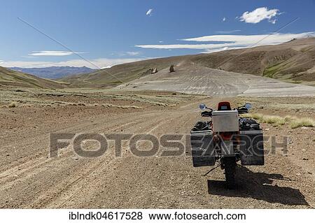 Stock Photo - Heavily packed motorcycle on a gravel road in the desert, Departamento Lago Buenos Aires, Santa Cruz Province, Argentina, South America. Fotosearch