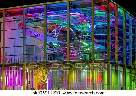 Stock Image - Helicopter museum colourfully illuminated, Bückeburg Germany. Fotosearch