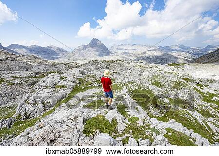 Stock Photo - Hiker looks into the distance, landscape of washed out karst stone rocks, Funtenseetauern, Steinernes Meer, Berchtesgaden National Park, Berchtesgadener Land, Upper Bavaria, Bavaria, Germany, Europe. Fotosearch