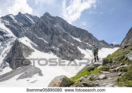 Stock Image - Hiker on the ascent to the Mörchnerscharte, Berliner Höhenweg, behind Großer and Kleiner Mörchner, Zillertaler Alps, Zillertal, Tyrol, Austria, Europe. Fotosearch