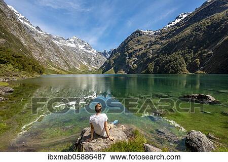 Hiker sitting on the shore, Lake Marian, Fiordland National Park, Te Anau, Southland, South Island, New Zealand, Oceania View Large Photo Image Stock Photo - Hiker sitting on the shore, Lake Marian, Fiordland National Park, Te Anau, Southland, South Island, New Zealand, Oceania. Fotosearch