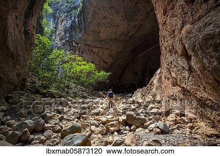 Stock Image - Hiker stands in a gorge, steep cliffs of Garganta Verde, Sierra de Cádiz, province of Cádiz, Spain, Europe. Fotosearch