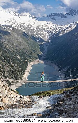 Hiker, woman on suspension bridge at the Olpererhütte, Schlegeis reservoir, Schlegeis reservoir, Zillertal Alps, Schlegeiskees glacier, Zillertal, Tyrol, Austria, Europe View Large Photo Image Picture - Hiker, woman on suspension bridge at the Olpererhütte, Schlegeis reservoir, Schlegeis reservoir, Zillertal Alps, Schlegeiskees glacier, Zillertal, Tyrol, Austria, Europe. Fotosearch