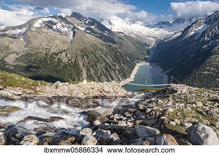Hiker, woman on suspension bridge at the Olpererhütte, Schlegeis reservoir, Schlegeis reservoir, Zillertal Alps, Schlegeiskees glacier, Zillertal, Tyrol, Austria, Europe View Large Photo Image Picture - Hiker, woman on suspension bridge at the Olpererhütte, Schlegeis reservoir, Schlegeis reservoir, Zillertal Alps, Schlegeiskees glacier, Zillertal, Tyrol, Austria, Europe. Fotosearch