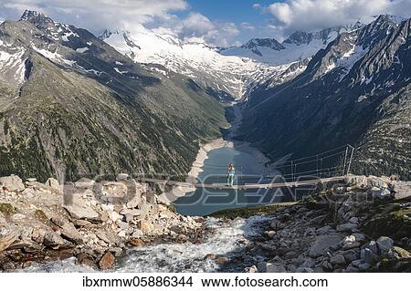 Hiker, woman on suspension bridge at the Olpererhütte, Schlegeis reservoir, Schlegeis reservoir, Zillertal Alps, Schlegeiskees glacier, Zillertal, Tyrol, Austria, Europe View Large Photo Image Picture - Hiker, woman on suspension bridge at the Olpererhütte, Schlegeis reservoir, Schlegeis reservoir, Zillertal Alps, Schlegeiskees glacier, Zillertal, Tyrol, Austria, Europe. Fotosearch
