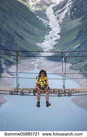 Hiker, woman on suspension bridge at the Olpererhütte, Schlegeis reservoir, Schlegeis reservoir, Zillertal Alps, Schlegeiskees glacier, Zillertal, Tyrol, Austria, Europe View Large Photo Image Stock Image - Hiker, woman on suspension bridge at the Olpererhütte, Schlegeis reservoir, Schlegeis reservoir, Zillertal Alps, Schlegeiskees glacier, Zillertal, Tyrol, Austria, Europe. Fotosearch