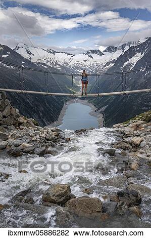 Hiker, woman on suspension bridge at the Olpererhütte, Schlegeis reservoir, Schlegeis reservoir, Zillertal Alps, Schlegeiskees glacier, Zillertal, Tyrol, Austria, Europe View Large Photo Image Stock Image - Hiker, woman on suspension bridge at the Olpererhütte, Schlegeis reservoir, Schlegeis reservoir, Zillertal Alps, Schlegeiskees glacier, Zillertal, Tyrol, Austria, Europe. Fotosearch