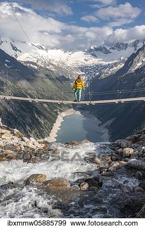 Hiker, woman on suspension bridge at the Olpererhütte, Schlegeis reservoir, Schlegeis reservoir, Zillertal Alps, Schlegeiskees glacier, Zillertal, Tyrol, Austria, Europe View Large Photo Image Stock Photo - Hiker, woman on suspension bridge at the Olpererhütte, Schlegeis reservoir, Schlegeis reservoir, Zillertal Alps, Schlegeiskees glacier, Zillertal, Tyrol, Austria, Europe. Fotosearch