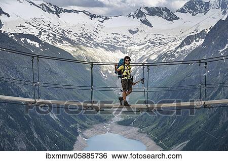 Hiker, woman on suspension bridge at the Olpererhütte, Schlegeis reservoir, Schlegeis reservoir, Zillertal Alps, Schlegeiskees glacier, Zillertal, Tyrol, Austria, Europe View Large Photo Image Stock Photograph - Hiker, woman on suspension bridge at the Olpererhütte, Schlegeis reservoir, Schlegeis reservoir, Zillertal Alps, Schlegeiskees glacier, Zillertal, Tyrol, Austria, Europe. Fotosearch
