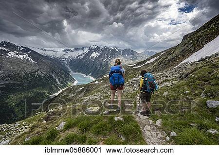 Stock Image - Hikers on the Berliner Höhenweg, Schlegeis reservoir, Schlegeis reservoir, Zillertal Alps, Schlegeiskees glacier, Zillertal, Tyrol, Austria, Europe. Fotosearch