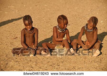 Stock Image - Himbamädchen grind grain, Kunene, Kaokoveld, Namibia, Africa. Fotosearch