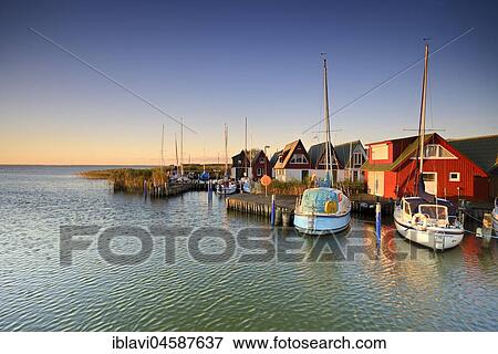 Holiday homes and sailboats in the harbour at Saaler Bodden, morning light, Althagen, Ahrenshoop, Fischland-Darß-Zingst, Mecklenburg-Western Pomerania, Germany, Europe View Large Photo Image Stock Photo - Holiday homes and sailboats in the harbour at Saaler Bodden, morning light, Althagen, Ahrenshoop, Fischland-Darß-Zingst, Mecklenburg-Western Pomerania, Germany, Europe. Fotosearch