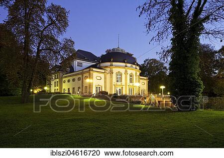 Stock Image - Illuminated theatre in the park in the blue hour, spa garden, Bad Oeynhausen, Ostwestfalen-Lippe, North Rhine-Westphalia, Germany, Europe. Fotosearch