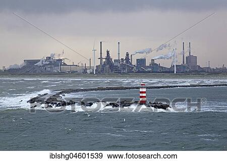 Stock Photo - Industrial area and lighthouse in the harbour entrance, Ijmuiden, Netherlands. Fotosearch
