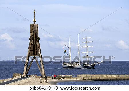 Stock Photo - Kugelbake with sailing ship on the Elbe, mouth of the Elbe into the North Sea, landmark of the city of Cuxhaven, Lower Saxony, Germany, Europe. Fotosearch