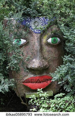 Magical woman face with red lips and green eyes looks through branches, sculpture, sculpture garden by the artist Jochen Bach, Plinzmühle, Plinz, Großkröbitz, Milda, Thuringia, Germany, Europe View Large Photo Image Stock Image - Magical woman face with red lips and green eyes looks through branches, sculpture, sculpture garden by the artist Jochen Bach, Plinzmühle, Plinz, Großkröbitz, Milda, Thuringia, Germany, Europe. Fotosearch