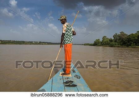 Stock Photograph - Man in front of a boat, Niger river, Niamey, Niger, Africa. Fotosearch