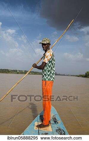 Stock Photography - Man in front of a boat, Niger river, Niamey, Niger, Africa. Fotosearch
