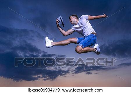 Stock Photo - Man jumping, sunset, Germany, Europe. Fotosearch
