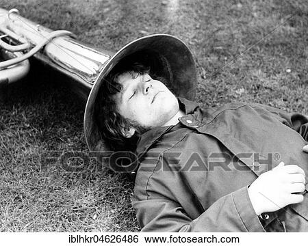Stock Photograph - Man sleeps with his head in tuba, ca. 1980s, East Berlin, GDR, Germany, Europe. Fotosearch