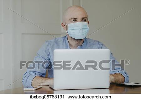 Man with face mask at home office View Large Photo Image Stock Image - Man with face mask at home office. Fotosearch
