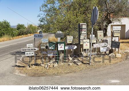 Picture - Many different mailboxes and signs are jumbled up by the roadside, Loulé, Faro, Algarve, Portugal, Europe. Fotosearch