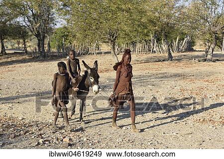 Stock Photo - Married Himbafrau, children ride on donkey, Kaokoveld, Namibia, Africa. Fotosearch