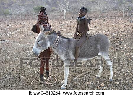 Picture - Married Himbafrau with girl on a donkey, Kaokoveld, Namibia, Africa. Fotosearch