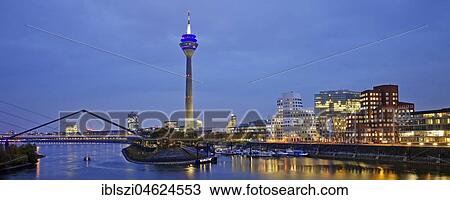 Stock Image - Media harbour with Rhine tower and Gehry buildings at dawn, Düsseldorf, North Rhine-Westphalia, Germany, Europe. Fotosearch
