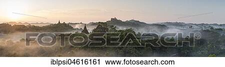 Stock Image - Mist over hills and stupas of Mrauk U at sunrise, Burma, Myanmar, Asia. Fotosearch