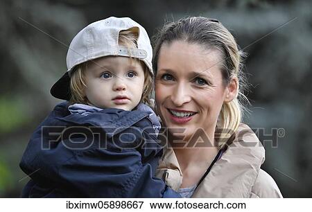 Mother holds son, 2 years old, in her arms, Stuttgart Baden-Württemberg, Germany, Europe View Large Photo Image Stock Photo - Mother holds son, 2 years old, in her arms, Stuttgart Baden-Württemberg, Germany, Europe. Fotosearch