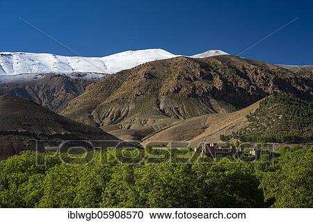 Stock Image - Mountain landscape with snow-covered mountain, in the foreground Kasbah, clay castle of the Berbers, Tighremt, Ait Bouguemez valley, Tabant, High Atlas, Morocco, Africa. Fotosearch