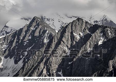 Mountain peaks, snow-covered mountains, dramatic mountain landscape with cloudy skies, Zillertal Alps, Zillertal, Tyrol, Austria, Europe View Large Photo Image Stock Photography - Mountain peaks, snow-covered mountains, dramatic mountain landscape with cloudy skies, Zillertal Alps, Zillertal, Tyrol, Austria, Europe. Fotosearch