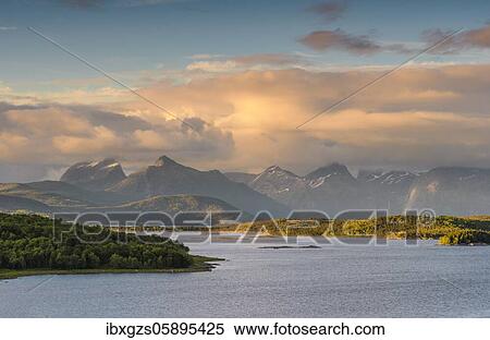 Mountain range in the evening light, in front calm fjord, Nordland, Norway, Europe View Large Photo Image Stock Photography - Mountain range in the evening light, in front calm fjord, Nordland, Norway, Europe. Fotosearch