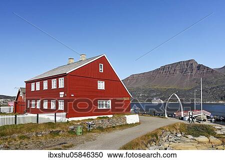 Stock Image - Museum at the landing stage for boats with jetty and archway made of whale jaw bone, Qeqertarsuaq, disco island, disco bay, Greenland, North America. Fotosearch
