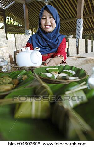 Muslim woman, 20 years old, serves tea and Javanese starters, Cadirejo Village, Magelang, Java, Indonesia, Asia View Large Photo Image Stock Photo - Muslim woman, 20 years old, serves tea and Javanese starters, Cadirejo Village, Magelang, Java, Indonesia, Asia. Fotosearch
