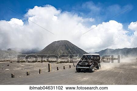 Stock Image - Off-road vehicle drives through the Tengger Caldera, behind Mt. Batok, National Park Bromo-Tengger-Semeru, Java, Indonesia, Asia. Fotosearch