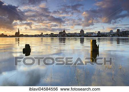 Stock Photograph - Old town and city harbour reflected in the river Warnow, morning light, Rostock, Mecklenburg-Western Pomerania, Germany, Europe. Fotosearch