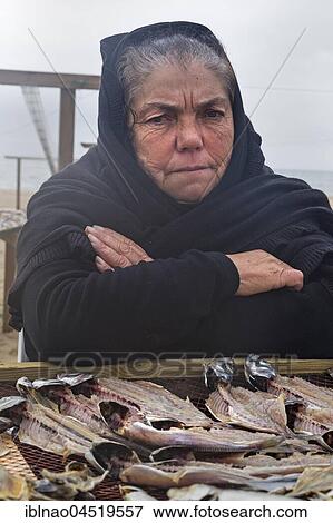 Older woman sells fish on the beach of Nazare, Portugal, Europe View Large Photo Image Stock Photo - Older woman sells fish on the beach of Nazare, Portugal, Europe. Fotosearch