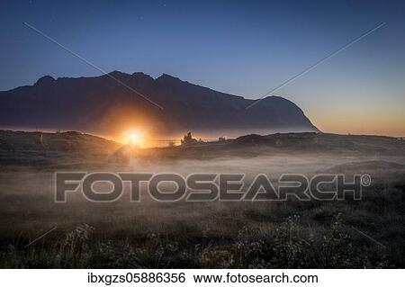Pasture at night with haze on the ground, behind warm light of a street lamp in front of a dark mountain range under a starry sky, Vågan, Lofoten, Nordland, Norway, Europe View Large Photo Image Stock Photograph - Pasture at night with haze on the ground, behind warm light of a street lamp in front of a dark mountain range under a starry sky, Vågan, Lofoten, Nordland, Norway, Europe. Fotosearch