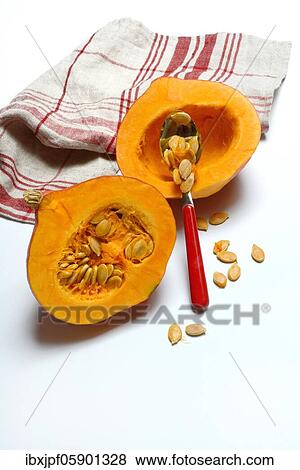 Stock Photo - Pumpkin, pumpkin halves and pumpkin seeds with spoon, Germany, Europe. Fotosearch