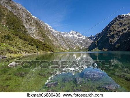Stock Image - Reflection in Lake Marian, Fiordland National Park, Te Anau, Southland, South Island, New Zealand, Oceania. Fotosearch