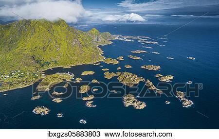 Stock Image - Road to Henningsvaer, numerous small rocky islands in the sea in front of green Lofotenberg, Vestvågøy, Lofoten, Nordland, Norway, Europe. Fotosearch