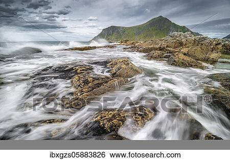 Stock Photograph - Rocks and wild sea surf, on the beach at Flakstad, Flakstadøy, Skagsanden, Flakstad, Lofoten, Nordland, Norway, Europe. Fotosearch